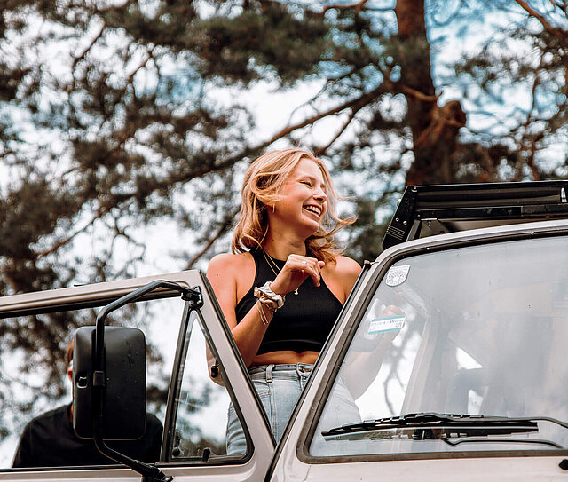 Junge Dame befindet sich in einem alten Bus und denkt über eine Auslandsreise Krankenversicherung nach.