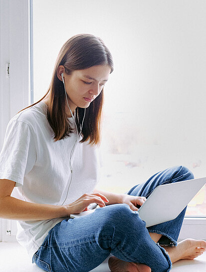 Mädchen sieht sich die Checkliste für ihren Krankenhausaufenthalt auf ihrem Laptop an.